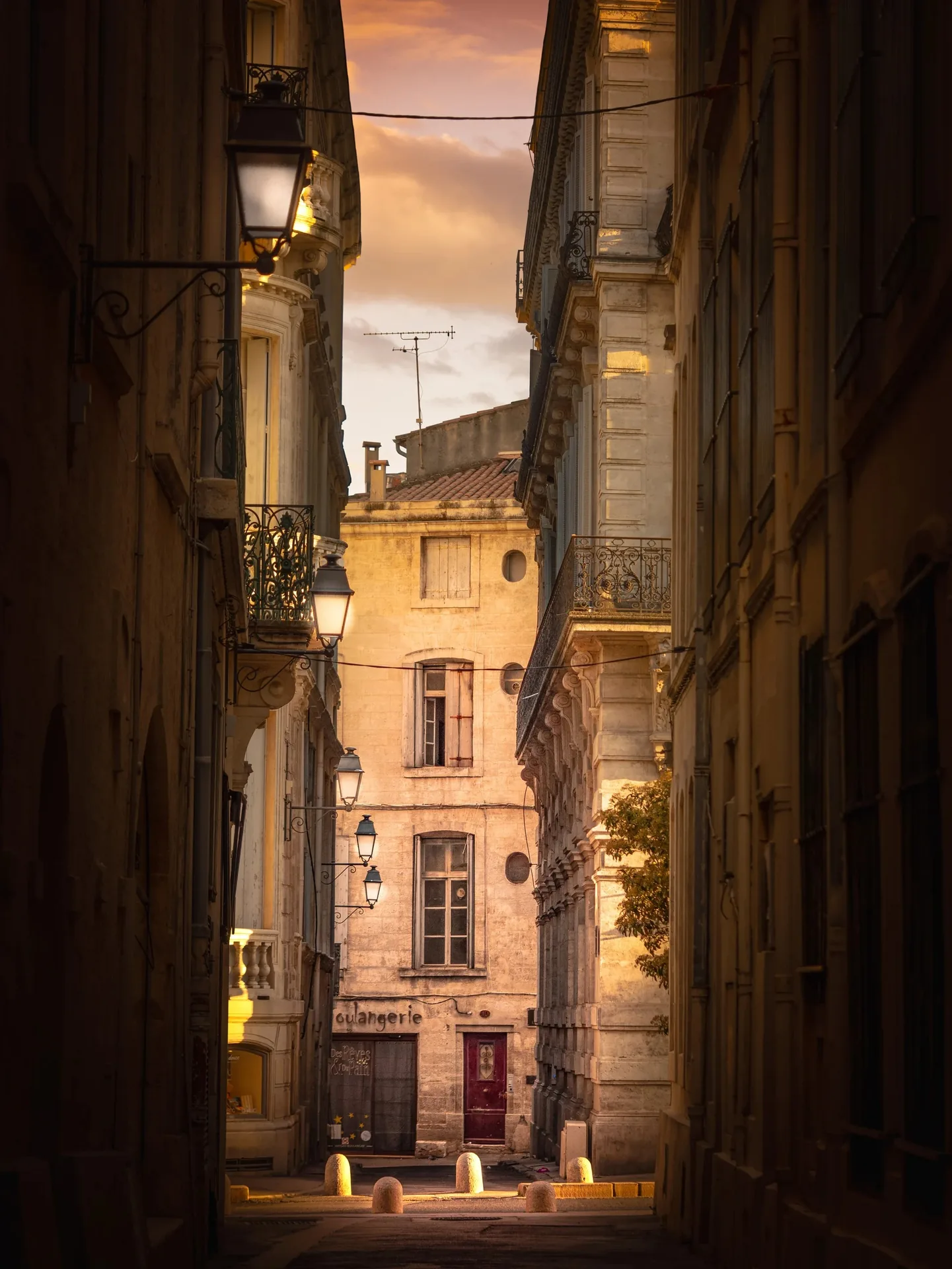 Ruelle ancienne de Montpellier au coucher du soleil avec lanternes