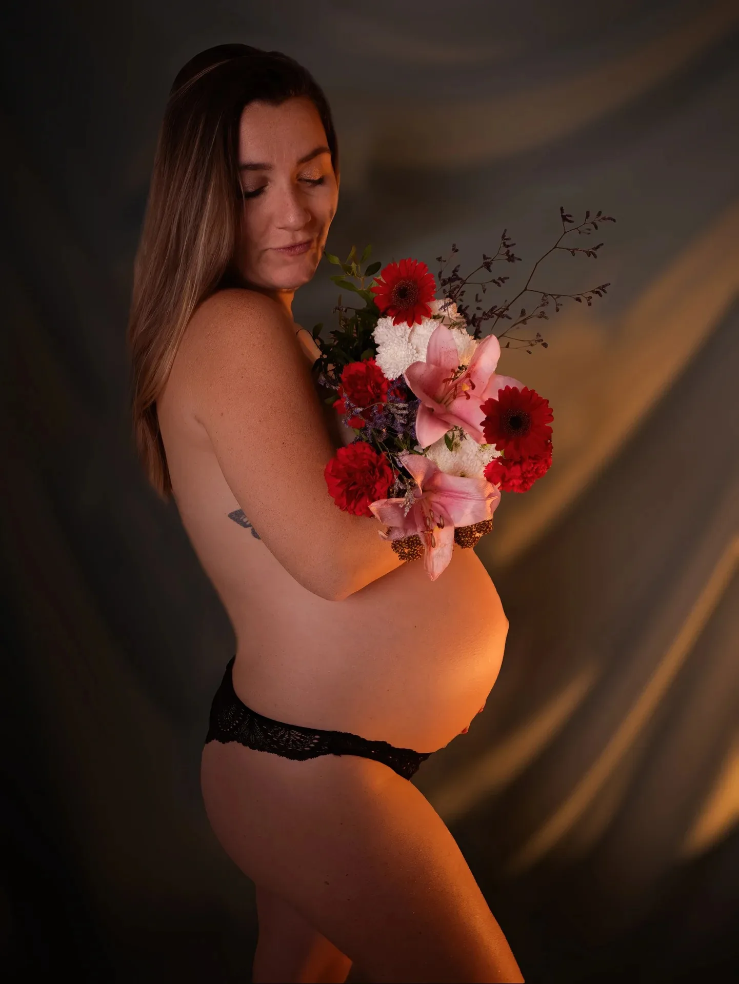 Portrait de grossesse avec bouquet de fleurs en studio