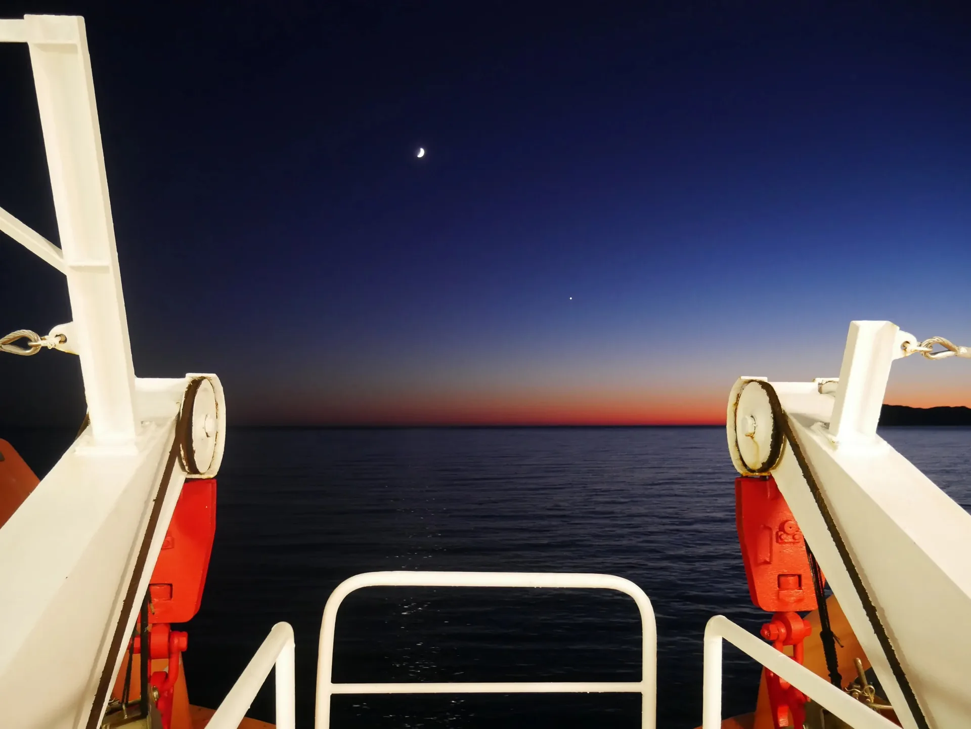 Vue depuis le pont d'un ferry sur la mer Méditerranée au coucher du soleil avec croissant de lune